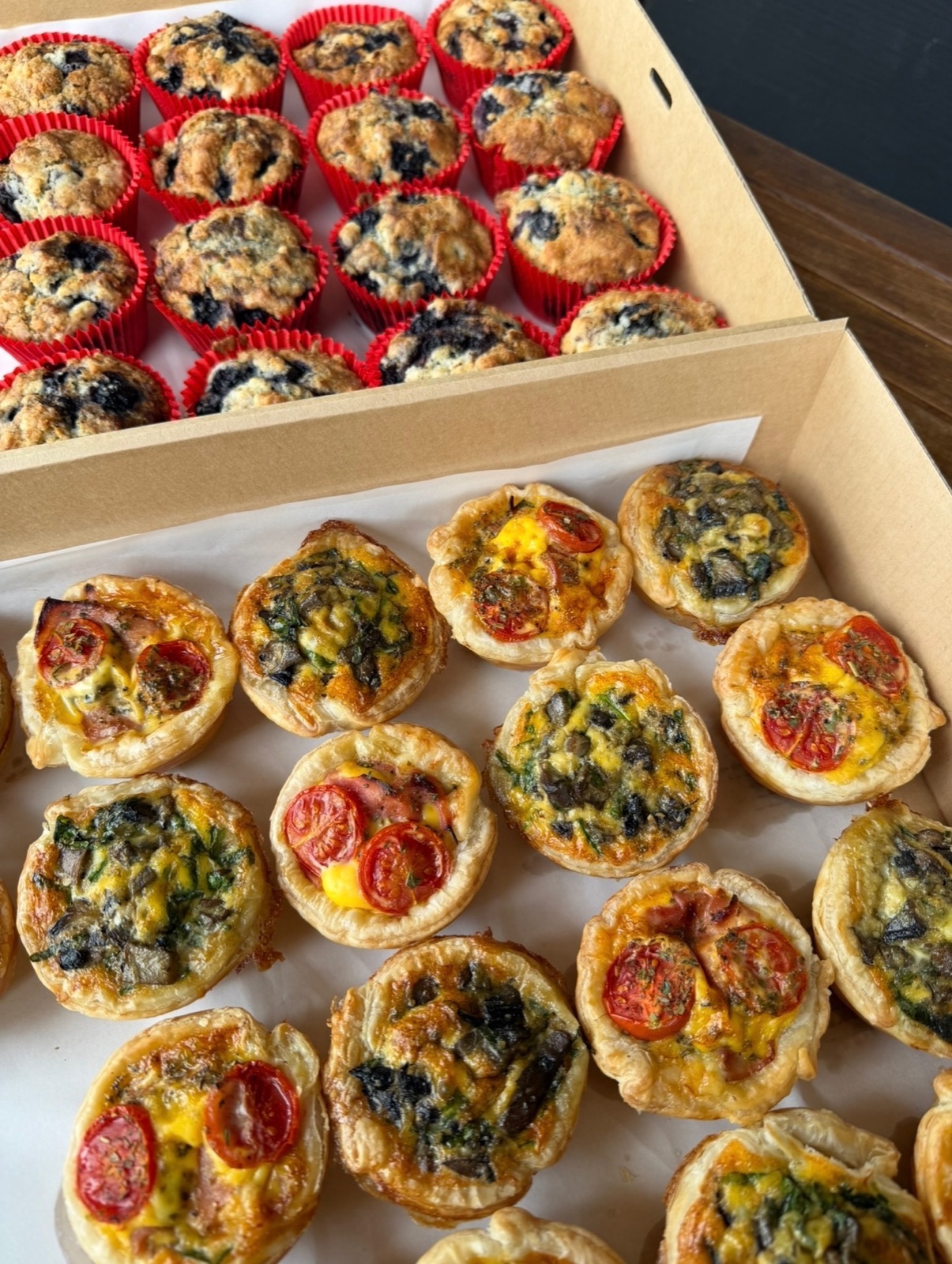 Boxes of blueberry muffins and savoury tarts